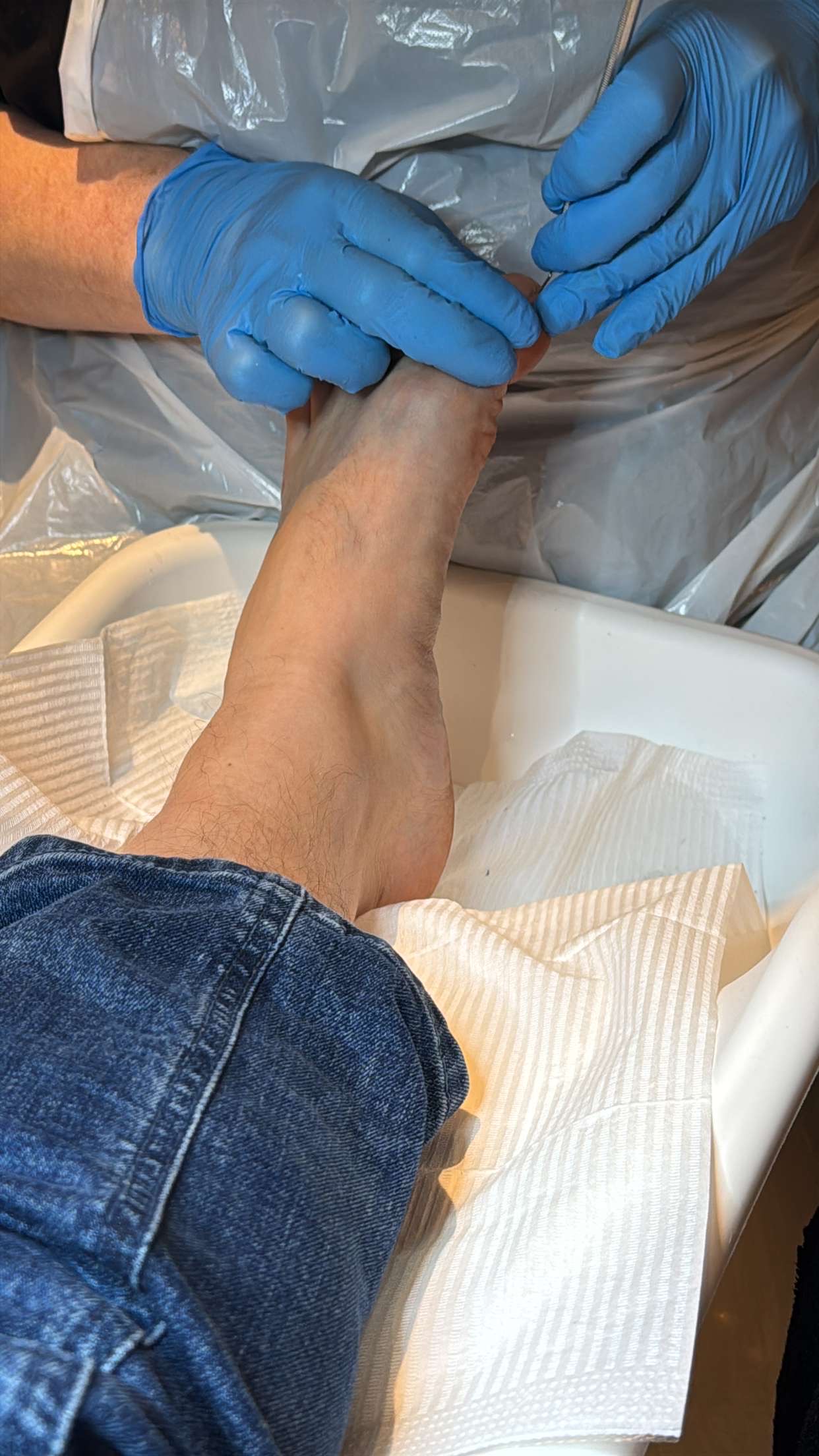 Een voet wordt behandeld met handschoenen aan, in de salon van Pedicure Ut Vuutje